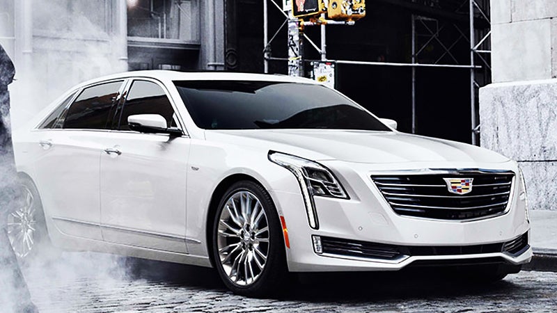 White Cadillac CT6 parked on urban street with fog