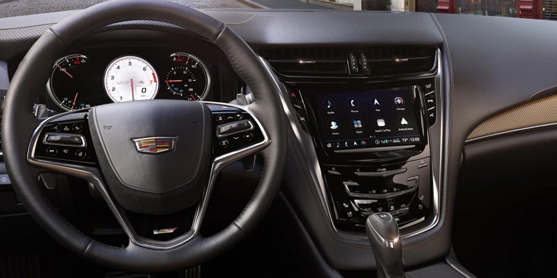 Cadillac CTS interior showing steering wheel and infotainment system