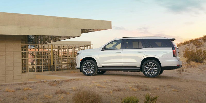 white Escalade-ESV is parked in front of a contemporary building
